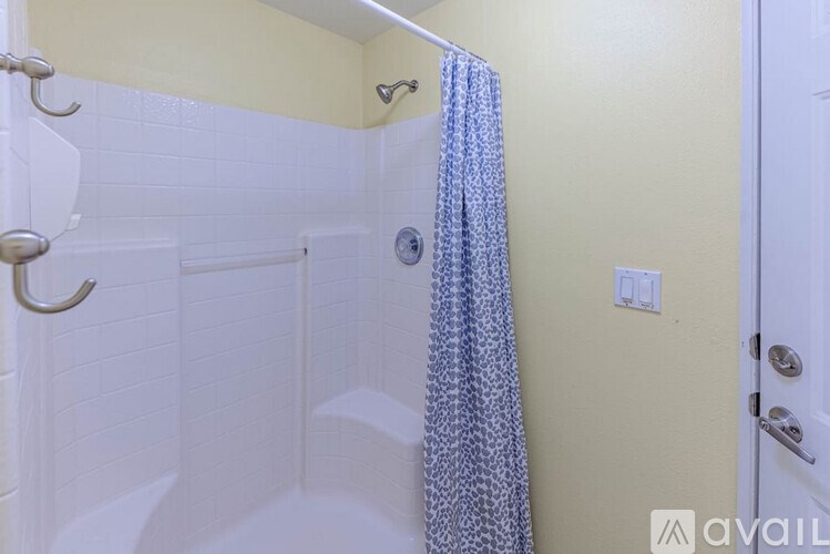 A bathroom with a shower curtain and a white door.