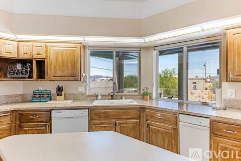 A kitchen with wooden cabinets and a large island in the middle.