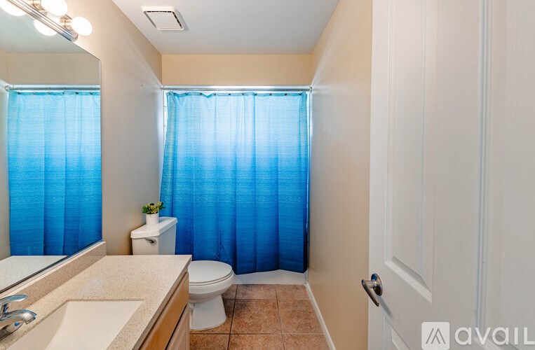 A bathroom with a toilet, sink, and shower curtain.