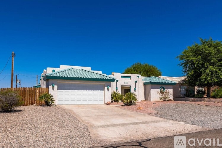 A house with a green roof and a white garage door is for sale.