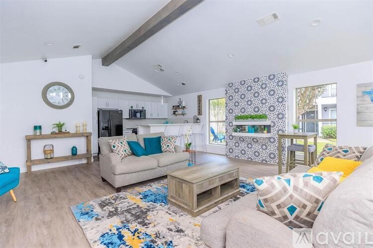 A living room with a grey couch and a patterned rug.