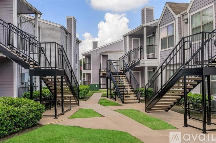 A row of houses with black railings on the staircases.