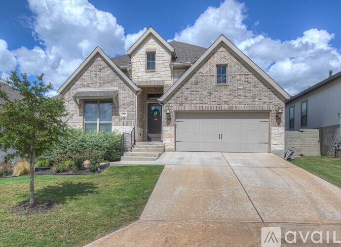 A house with a driveway and a tree in front.