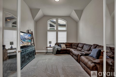 A living room with a brown leather couch and a television.