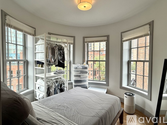 A bedroom with a large bed and a window overlooking a city street.