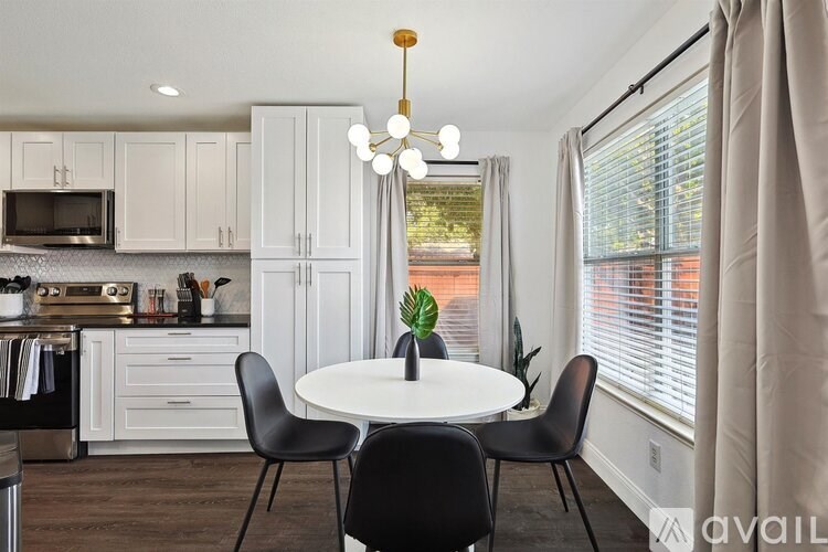 A kitchen with a table and chairs in front of a window.
