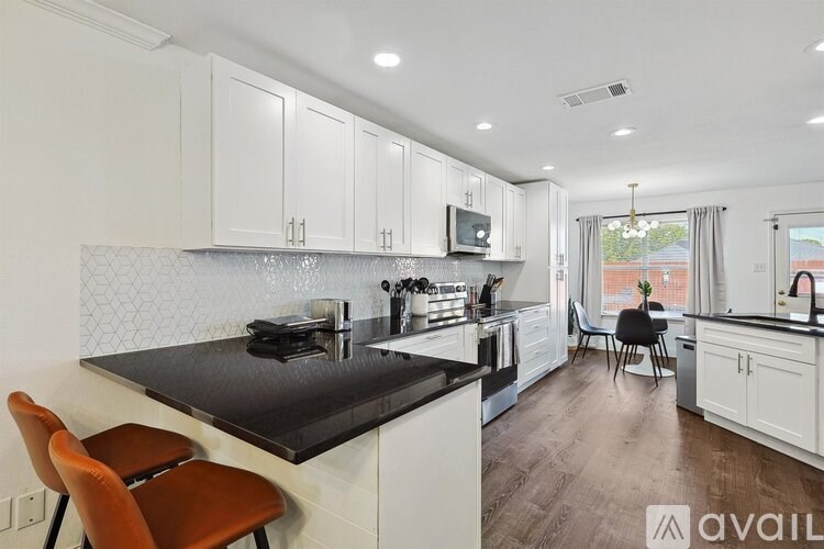 A kitchen with white cabinets and a black countertop.