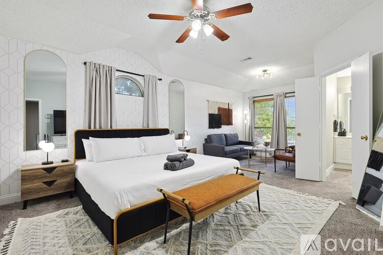 A bedroom with a large bed and a ceiling fan.