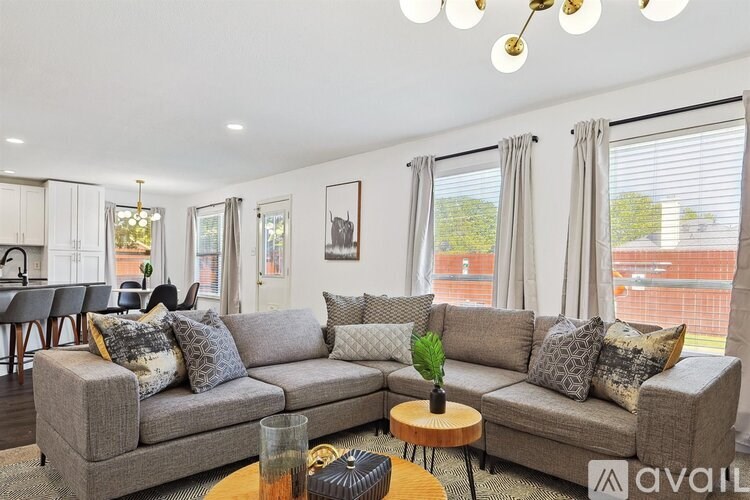 A living room with a grey sofa, a wooden coffee table, and a chandelier.