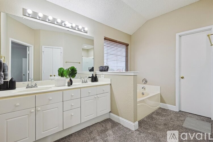 A bathroom with a vanity, two sinks, and a large mirror.