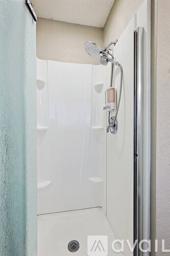 A shower head with a hand held shower attached to the wall.