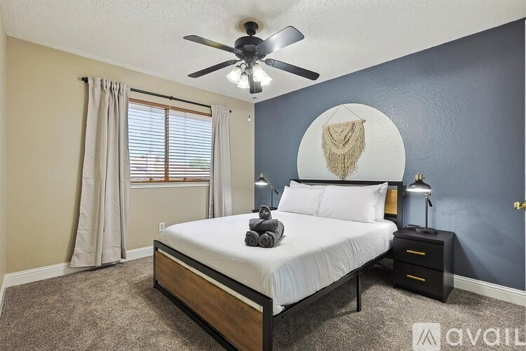 A bedroom with a bed, nightstand, and a ceiling fan.
