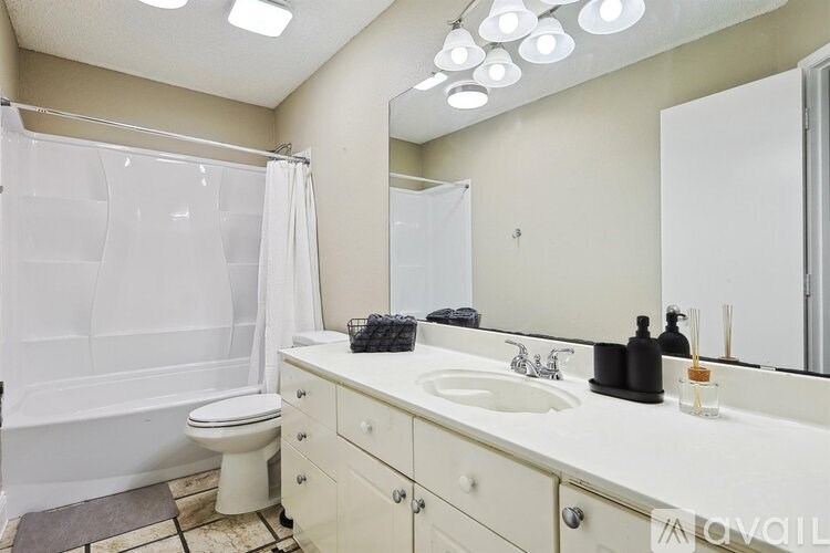 A white bathroom with a toilet, sink, and shower.
