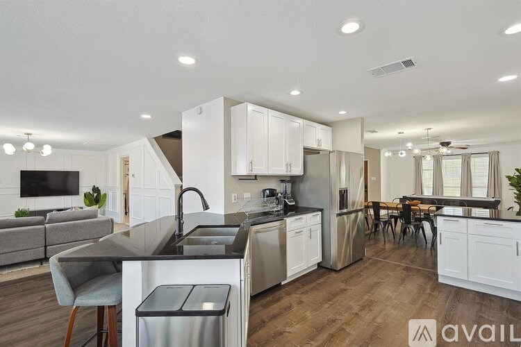 A modern kitchen with white cabinets and stainless steel appliances.