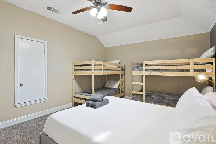 A bedroom with a white bed and two bunk beds.