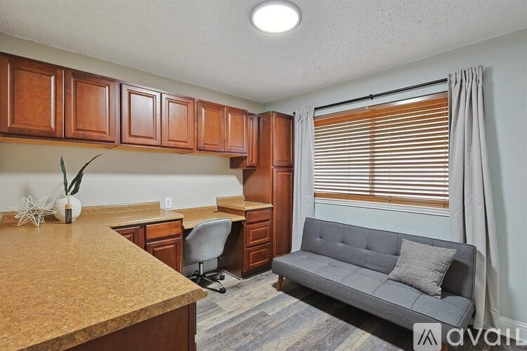A kitchen with a couch and a desk.