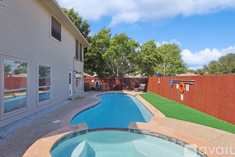 A residential backyard with a small pool and a wooden fence.