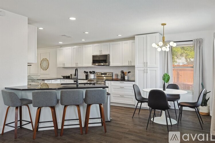 A kitchen with a bar area and a dining table.
