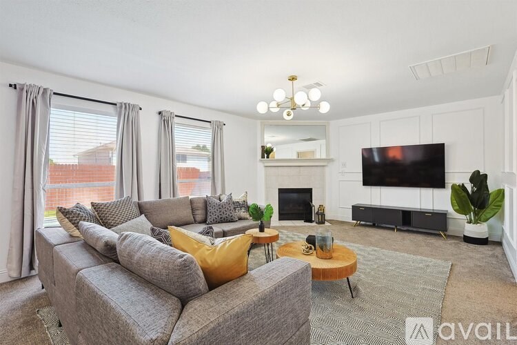 A living room with a grey couch, a coffee table, a fireplace, and a television.