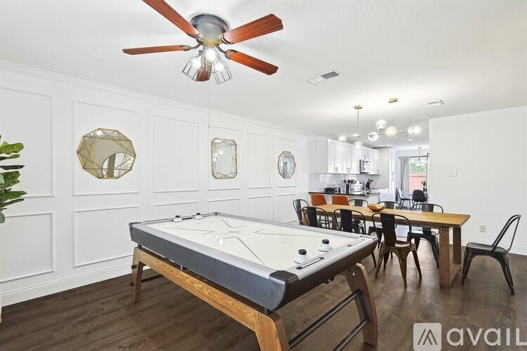 A room with a pool table and a fan.