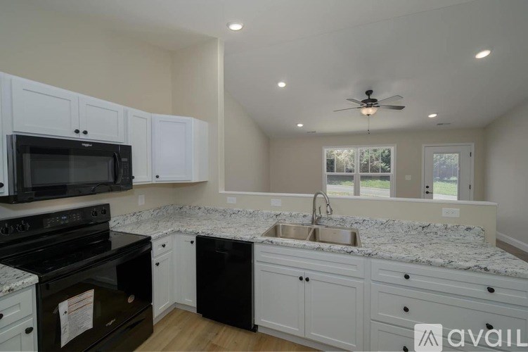 A kitchen with white cabinets and a black stove top oven.