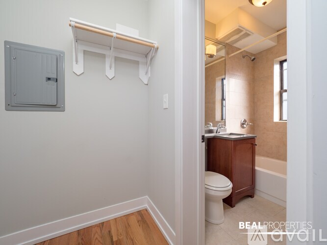 A bathroom with a toilet, sink, and a mirror.
