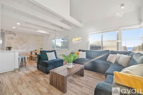 A living room with a black couch and a wooden coffee table.