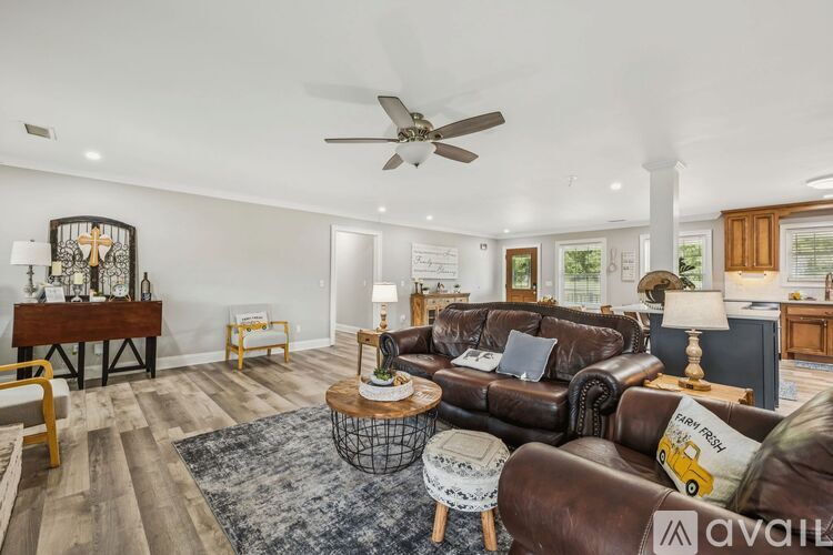 A living room with a brown leather couch and a wooden coffee table.