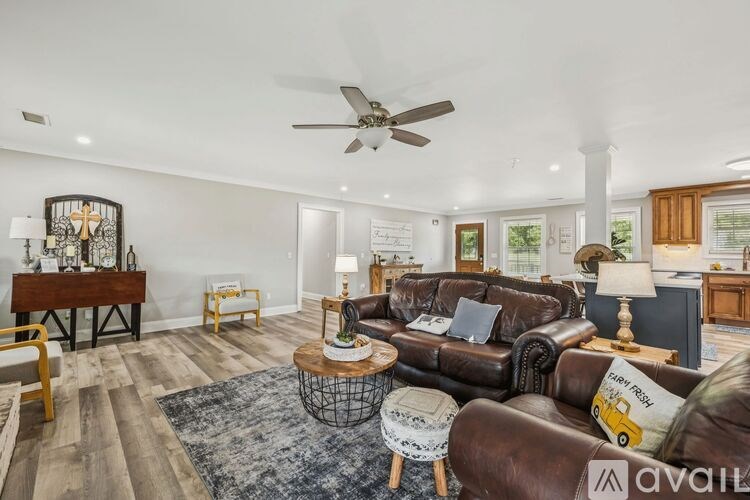 A living room with a brown leather couch and a wooden coffee table.