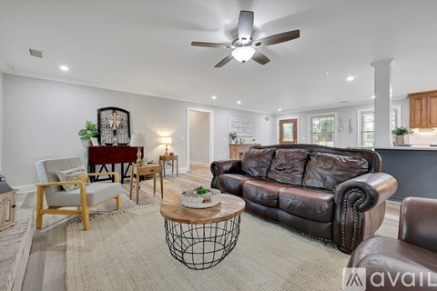 A living room with a brown leather couch and a wooden coffee table.
