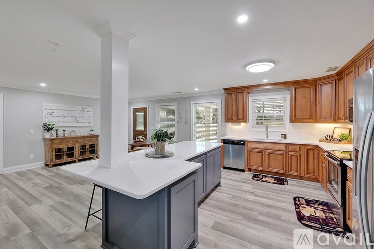 A kitchen with wooden cabinets and a white island.