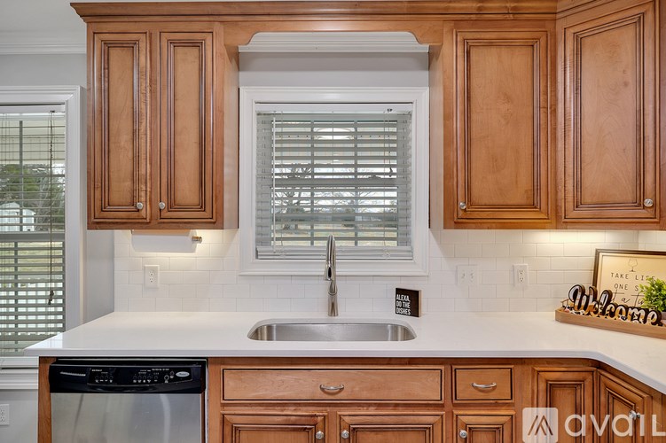 A kitchen with wooden cabinets and a stainless steel sink.