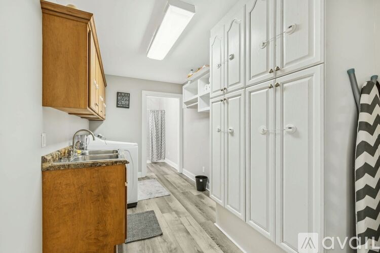 A kitchen with a wooden cabinet and a bowl on the shelf.