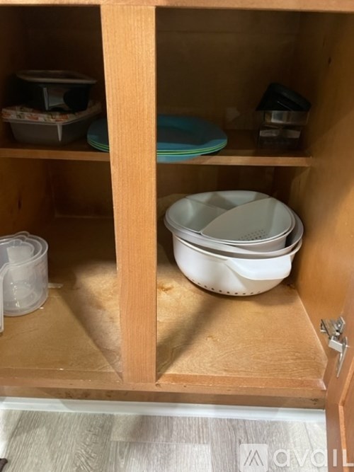 A kitchen cabinet with a variety of dishes and containers.