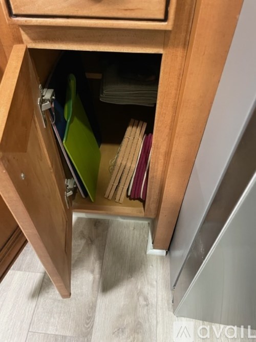 A drawer with a green folder and some books is open.