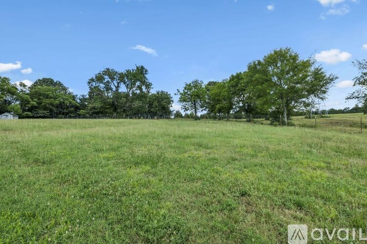 A kitchen with a stove top oven and a cabinet with glasses and plates on it.