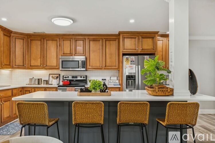 A living room with a brown leather couch and a ceiling fan.