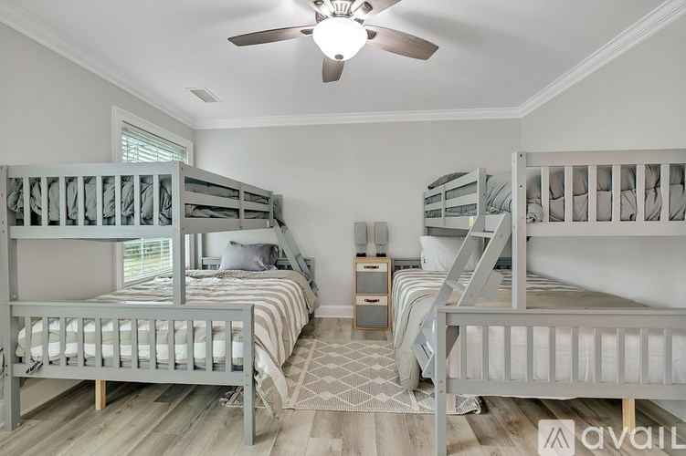 A room with two bunk beds and a ceiling fan.