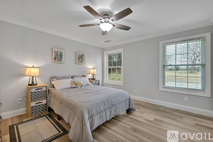 A bedroom with a bed, two lamps, and a ceiling fan.