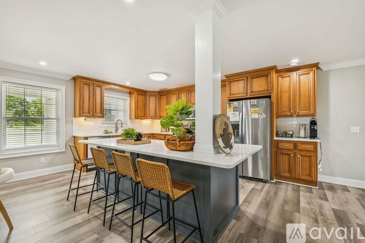 A modern kitchen with wooden cabinets and a dining table set for four.