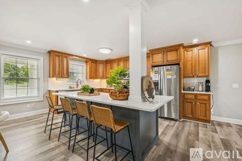 A modern kitchen with wooden cabinets and a dining table set for four.