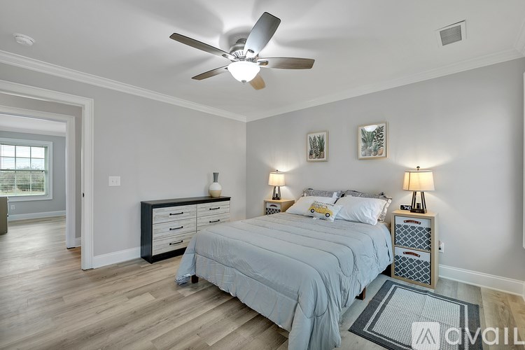 A bedroom with a bed, nightstands, and a ceiling fan.