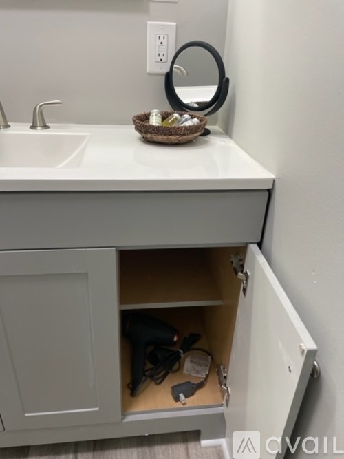 A bathroom vanity with a basket on top of it.
