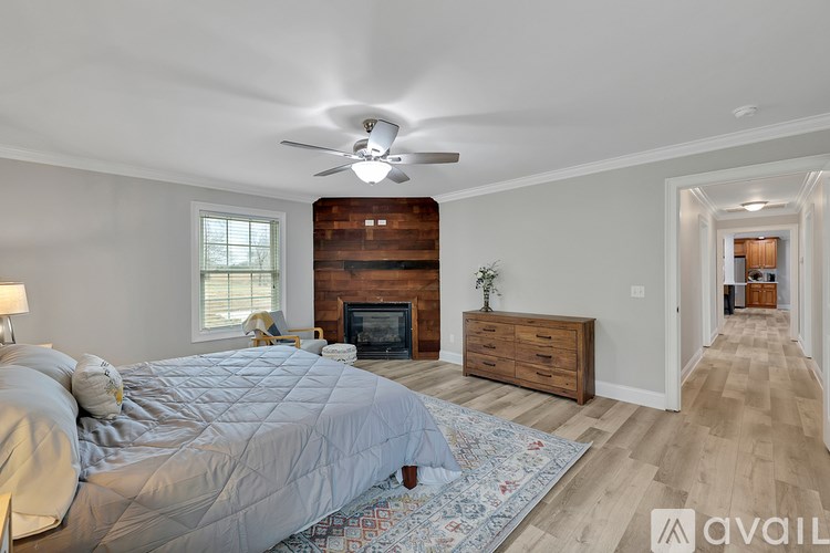 A bedroom with a large bed and a fireplace.