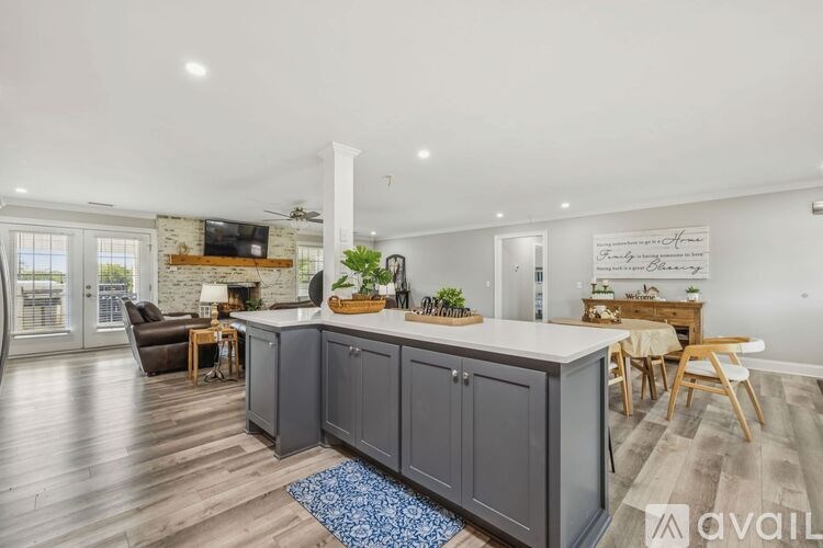 A spacious living room with a black leather couch and a wooden coffee table.