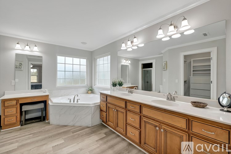 A bathroom with a large tub, double sinks, and a fireplace.