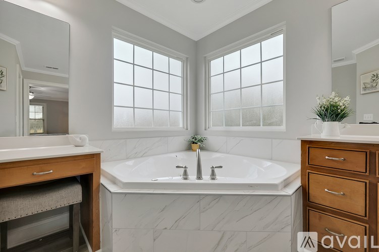 A bathroom with a marble tub and a window.