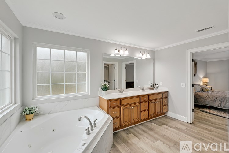 A bathroom with a tub, sink, and mirror.
