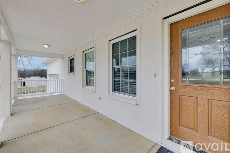 A room with a white wall and a wooden door.