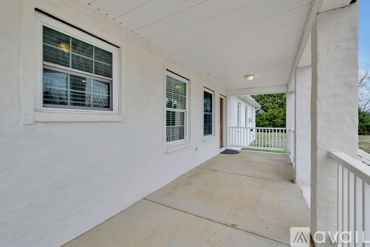 A white building with a balcony and a window.